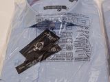 two shirts wrapped in plastic bags on a table