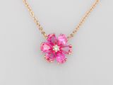 un collier avec une fleur rose sur une chaîne en or