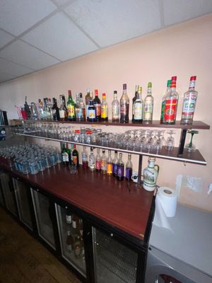 de nombreuses bouteilles et verres sur les étagères du bar