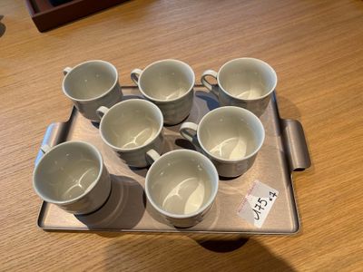 un plateau sur lequel sont posées six tasses, posé sur une table