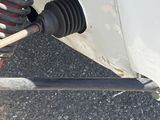 un gros plan sur la roue avant et la suspension d'une voiture