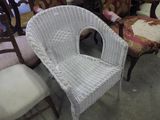a white wicker chair and two chairs in a room