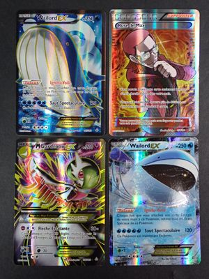 quatre cartes de pokémon différentes sont affichées sur une surface noire