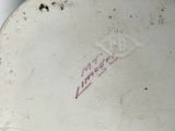 a white toilet with a red and black sticker on it