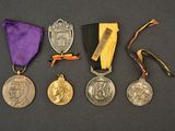 several medals are displayed on a black surface with a purple ribbon