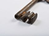 an old rusty key on a white surface