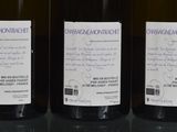 three bottles of wine are lined up on a table