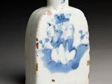 a small blue and white vase with a bird on it
