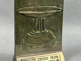 une plaque en bronze sur laquelle figure l'image d'un bol