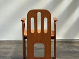 a wooden chair that is sitting in front of a wall