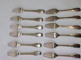 six forks and six knives are lined up on a white surface