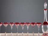 de nombreux verres à vin alignés les uns à côté des autres près d'une carafe