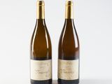 two bottles of wine sitting next to each other on a white surface