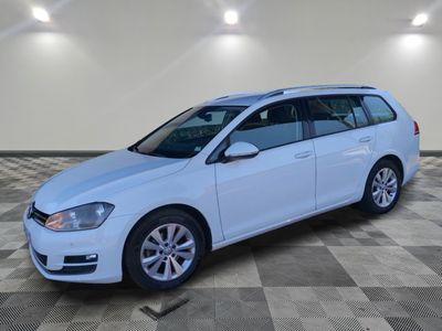 a white volkswagen golf wagon parked in a garage