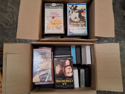 une boîte remplie de films et de DVD posée par terre