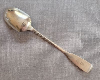 une cuillère en argent avec un manche de cuillère sur une table