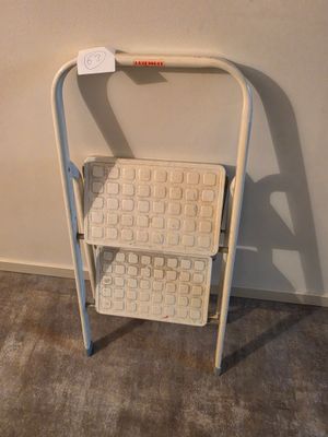 une chaise blanche sur laquelle est posé un panier, dans une pièce