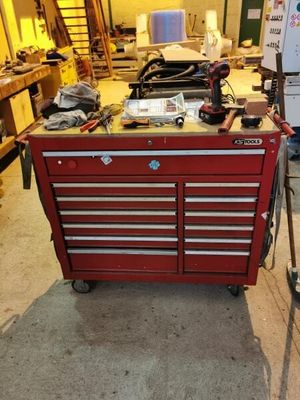 une boîte à outils rouge sur laquelle sont posés des outils, dans un garage