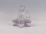 trois vases en verre posés sur un socle, sur une surface blanche