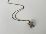 a close up of a necklace on a white surface with a star on it