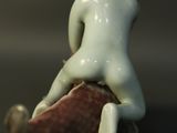 a figurine of a woman sitting on top of a fish