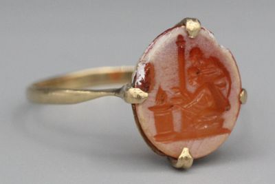 une image d'une bague en or avec une pierre rouge au centre