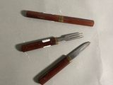 trois couteaux et une fourchette sur une table