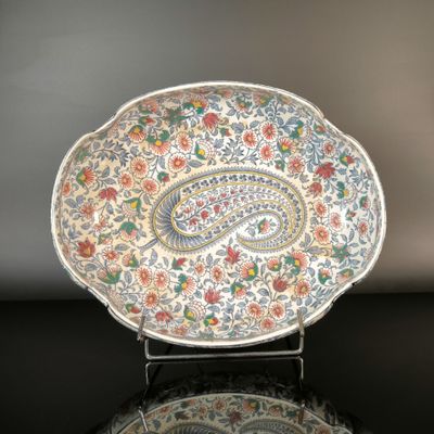 a plate with a paisley design on it on a table