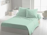 une photo d'un lit avec des draps et des oreillers vert menthe