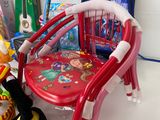a red chair with a red seat next to a pile of toys