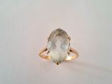 un gros plan d'une bague en or sertie d'une pierre blanche