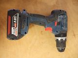 a close up of a corded drill on a wooden table