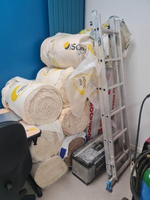 une échelle posée à côté d'un tas de moquettes
