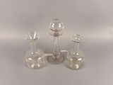three glass vases and a candle holder on a table