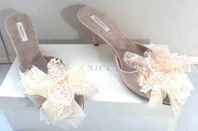 une paire de chaussures pour femme ornées de nœuds et de dentelle, posée sur une boîte blanche