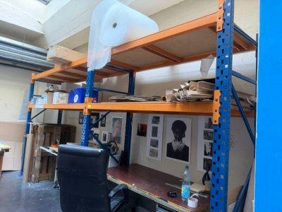 une pièce avec beaucoup d'étagères et de tableaux accrochés au mur