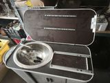 a metal sink sitting inside of a case on top of a table