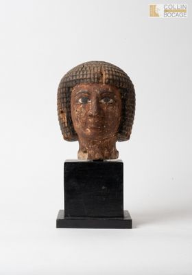 statue représentant la tête d'une femme, posée sur un socle noir