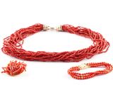 a close up of a red necklace and bracelet on a white surface