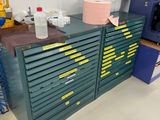 une armoire verte avec de nombreux tiroirs et une machine bleue