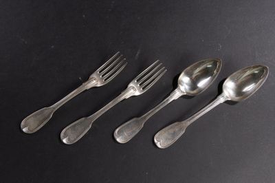 quatre cuillères et une fourchette sont alignées sur une surface noire