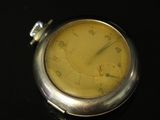 a close up of a pocket watch on a black surface