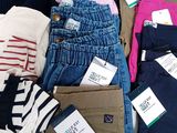 a pile of clothing that is on a bed