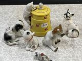 cinq figurines représentant des chiens et un chat posées sur une table