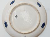 a white plate with blue flowers on it on a white surface