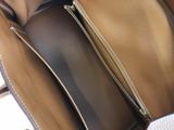 the inside of a brown and white handbag with a zipper