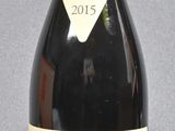 bottle of red wine with a red cap on a grey background