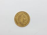 a gold coin on a white surface with a white background