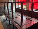 des tables et des bancs dans un restaurant, avec une lumière rouge qui filtre à travers les fenêtres