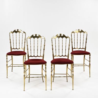 quatre chaises dorées avec des coussins rembourrés rouges, sur fond blanc